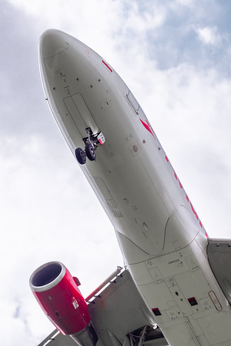 A thrilling upward angle capturing an airplane's undercarriage in flight over Bogotá, Colombia.