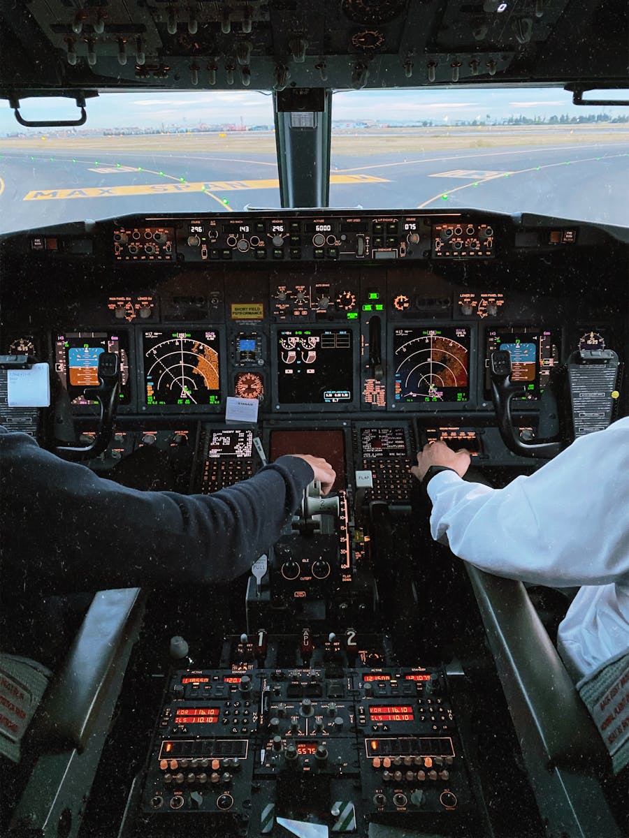 Interior of a cockpit with pilots operating controls, showcasing advanced avionics and flight instruments.